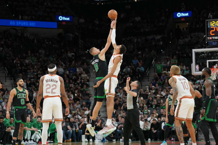 Dec 31, 2023; San Antonio, Texas, USA; Boston Celtics center Kristaps Porzingis (8) and San Antonio Spurs center Victor Wembanyama (1) go after the opening tip in the first half at Frost Bank Center.